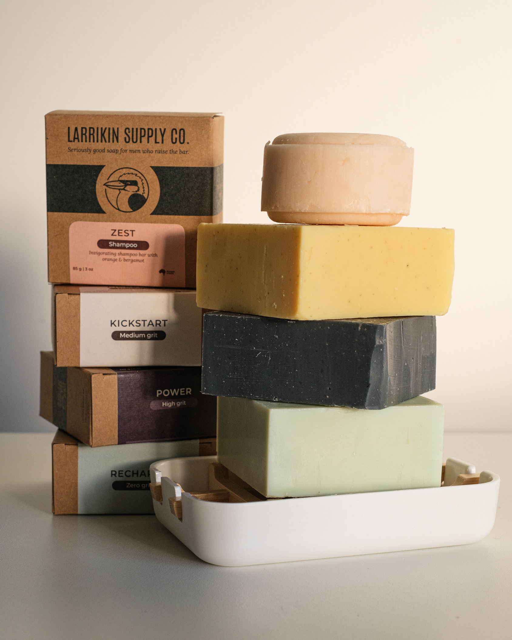 Stack of various soaps and Larrikin Supply Co packaging on a neutral background