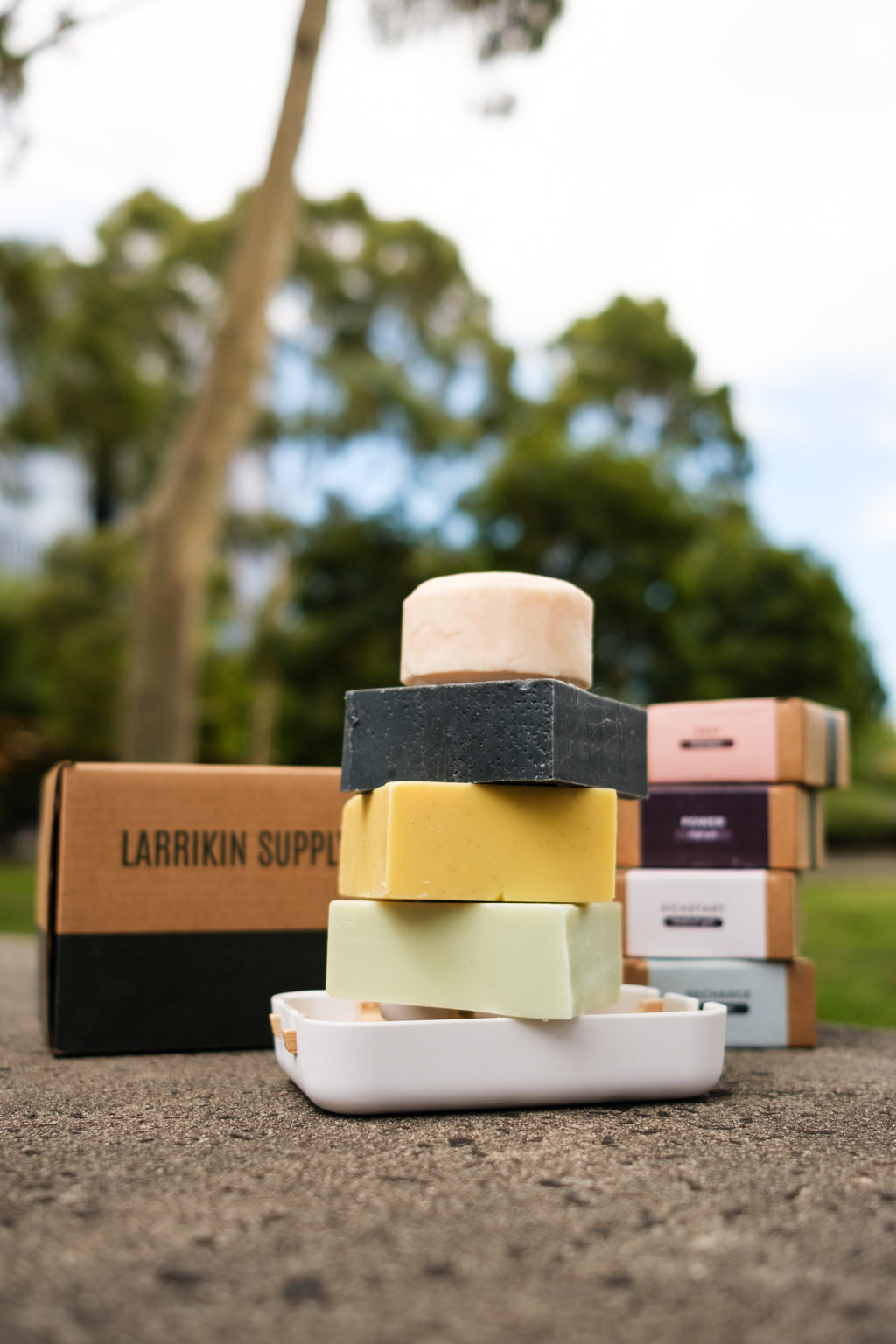 Stack of soap bars on a stone surface with blurred greenery in the background